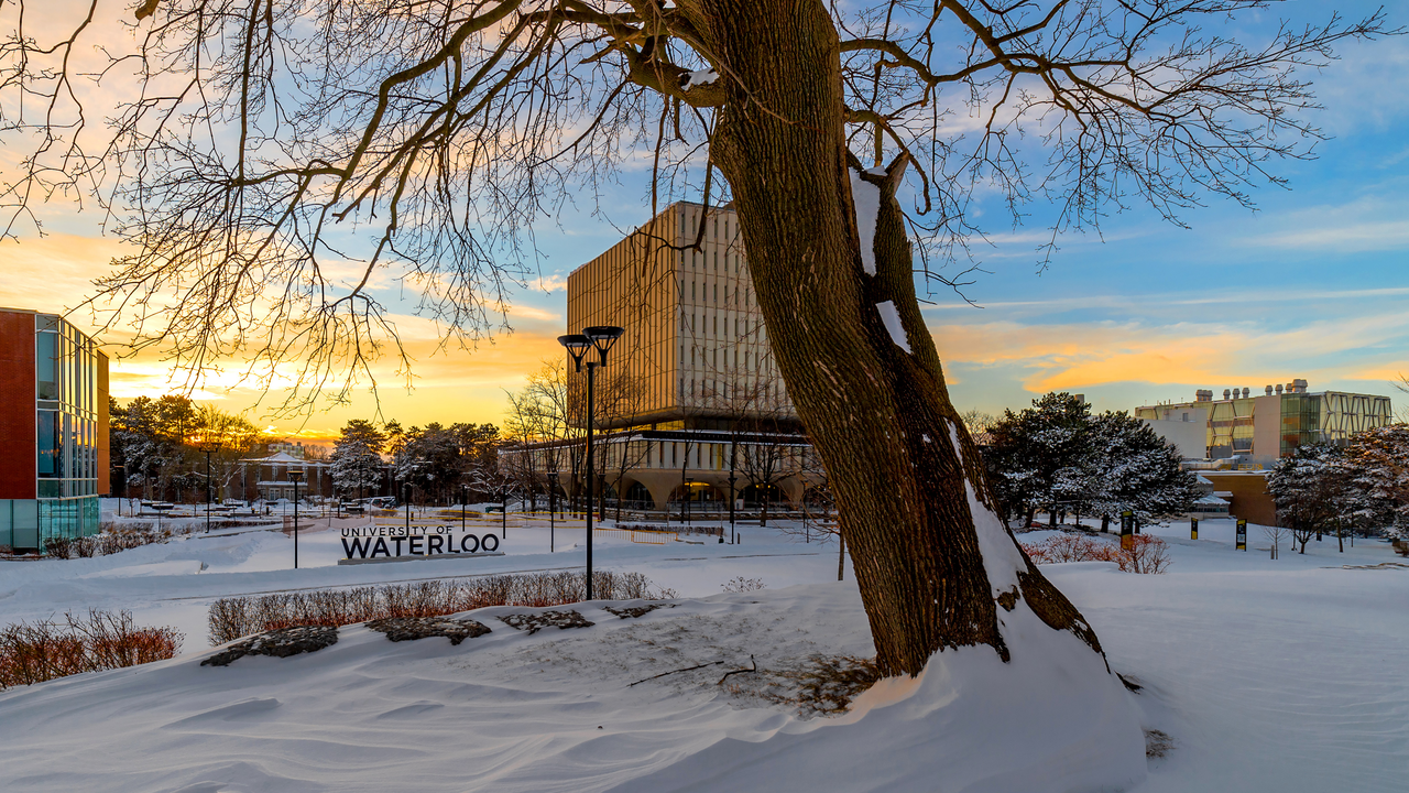 University of Waterloo sign and Dana Porter library at sunset