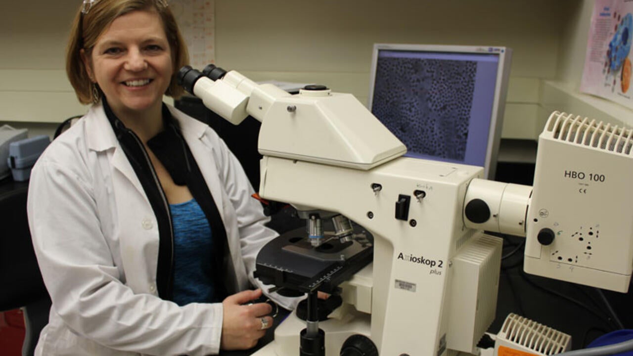 Monica Emelko at the lab in front of a microscope