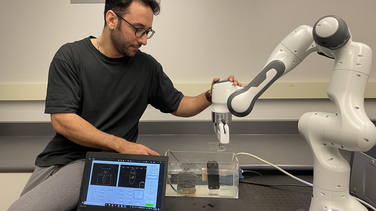 Engineering research associate Moslem Sadeghi Goughari checks his ultrasound robot arm
