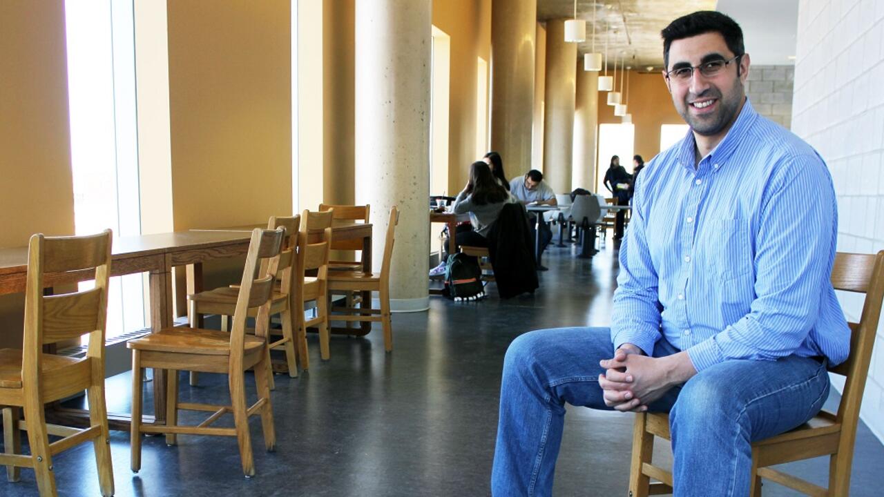 Nasser Abukhdeir sits in a chair along a hallway