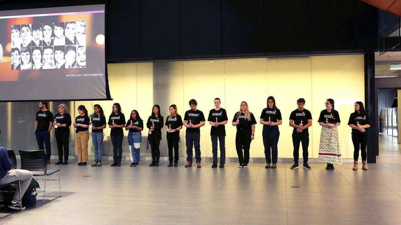 15 Waterloo engineering students holding a candle remembering the 14 victims of the Polytechnique Montréal attack