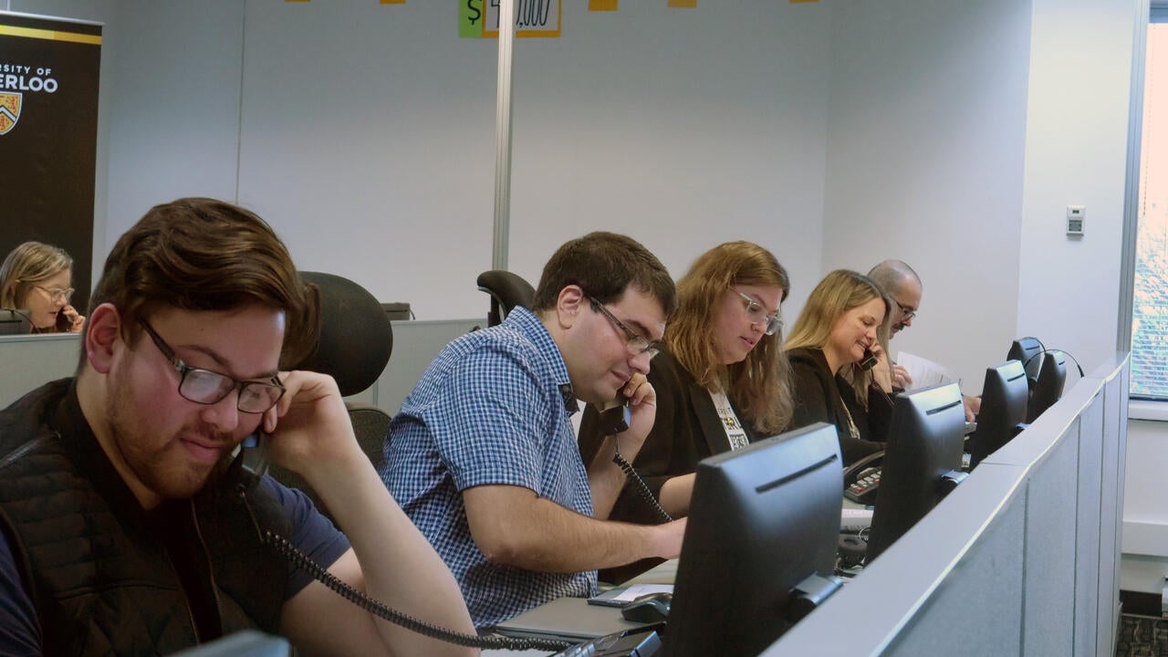 Men and women talk on phones in a call centre