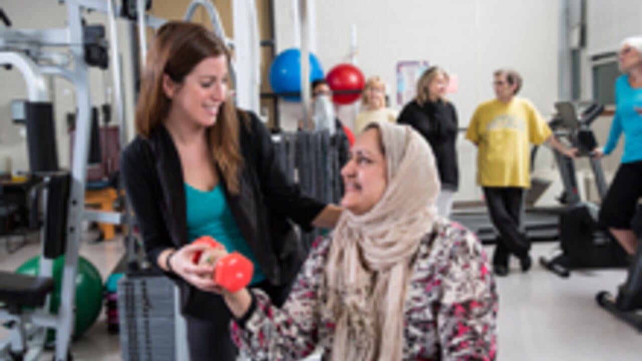 student helping woman with fitness training