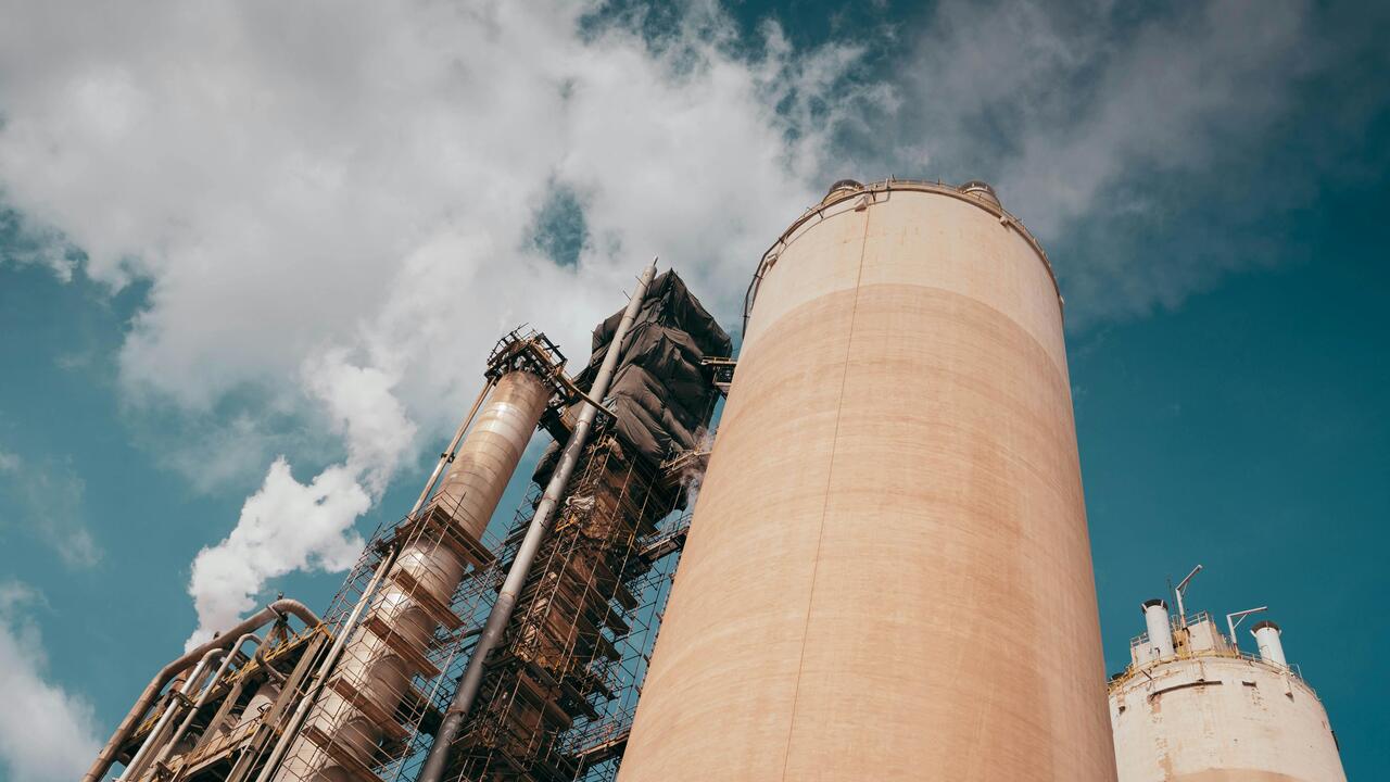 A view of smoke stacks with smoke coming out of them