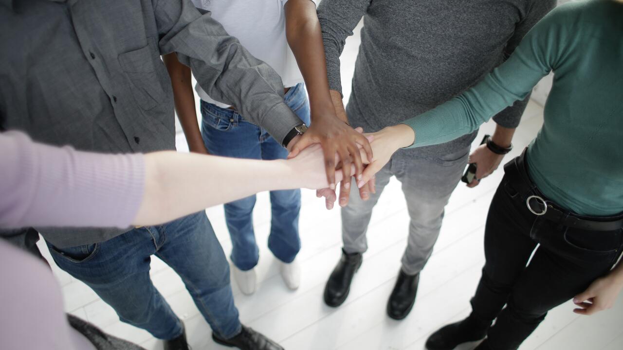 A group of people put their hands together in a circle