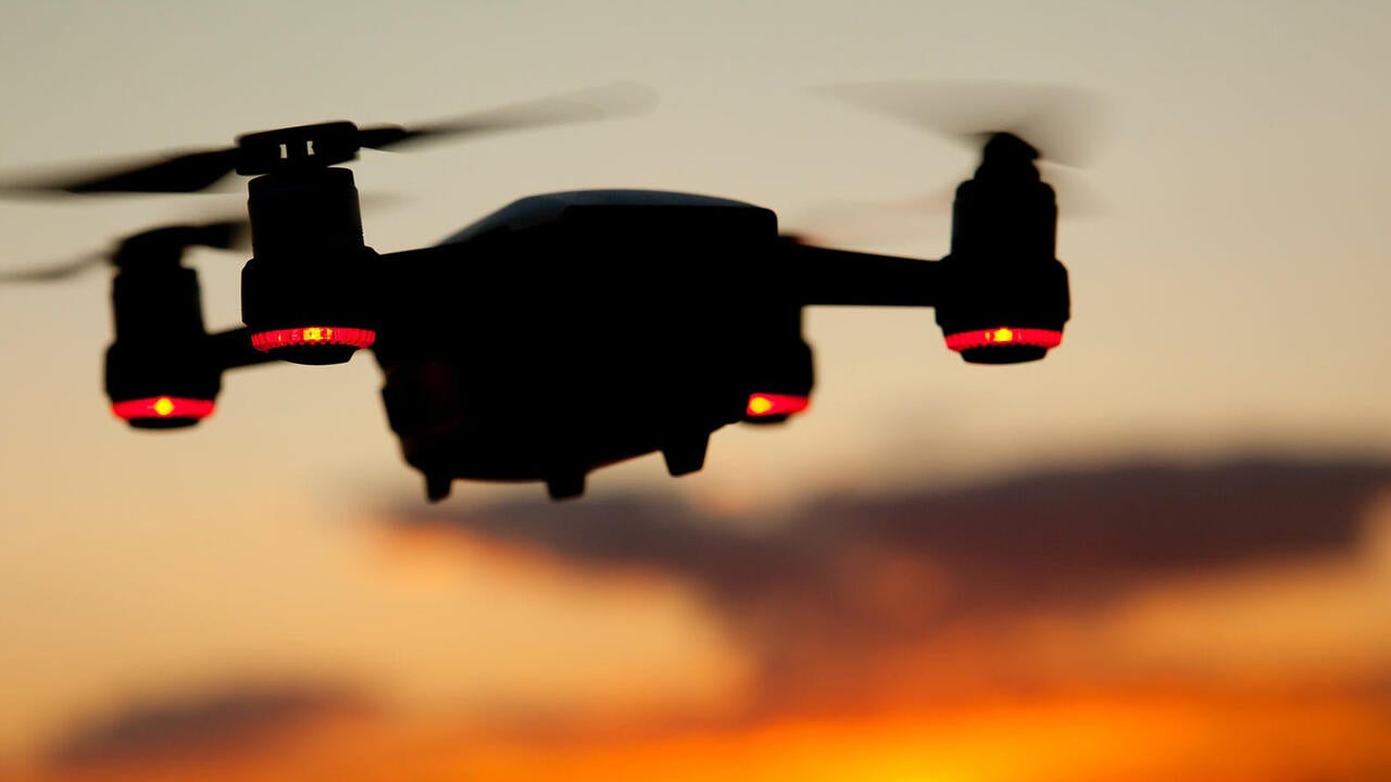 Drone flying towards sunset