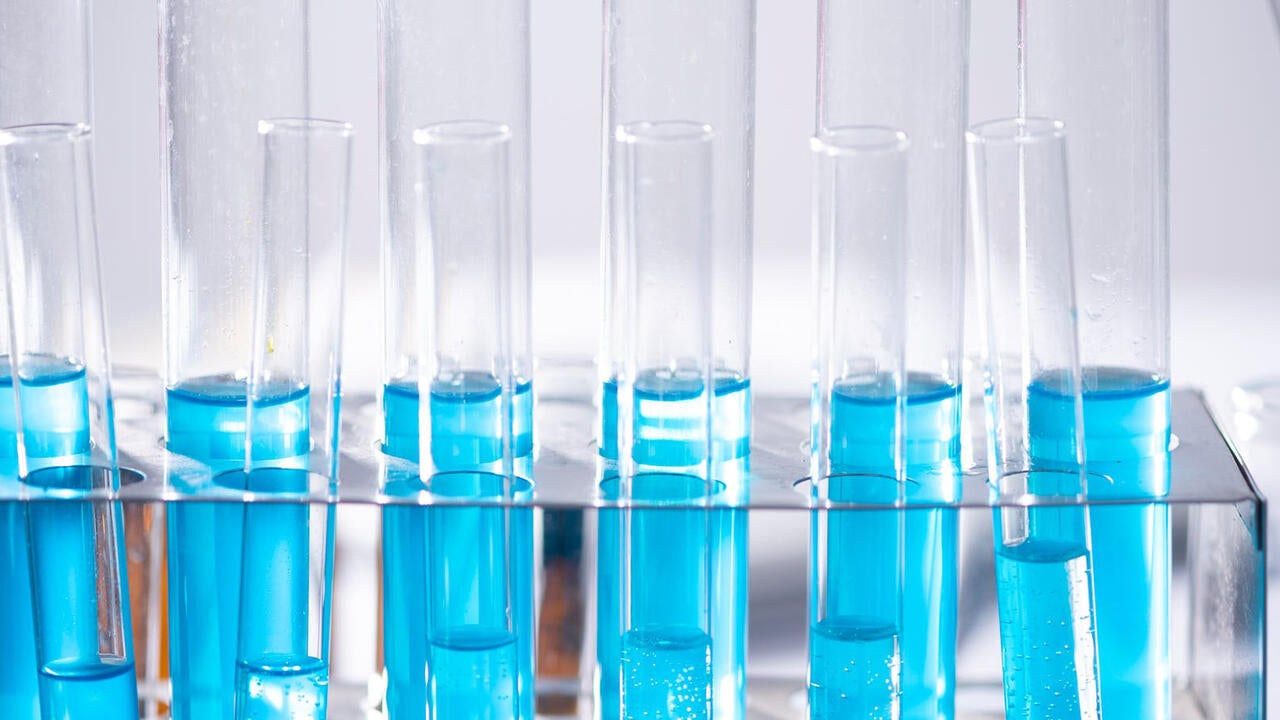 A line of testing tubes with blue substance
