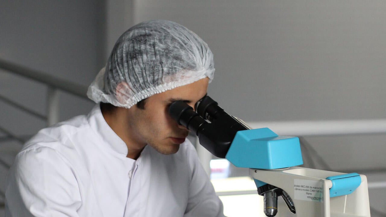 Doctor looking through medical microscope