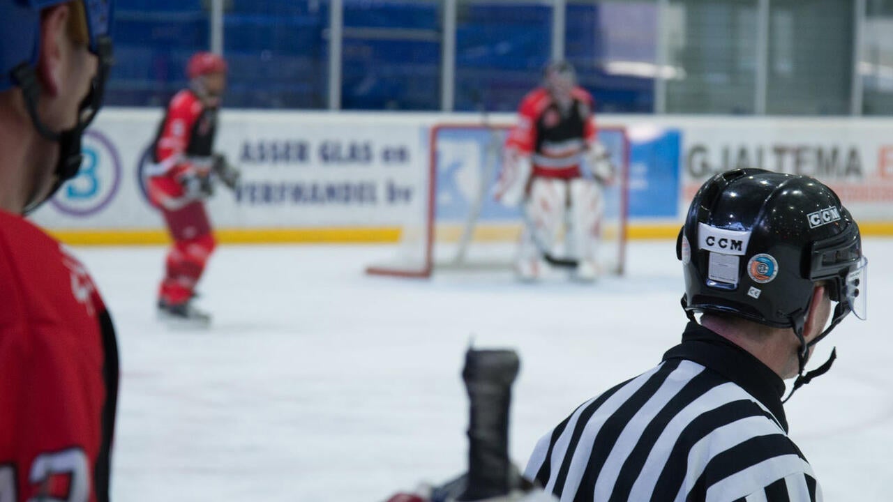 Referee in front of hockey ring