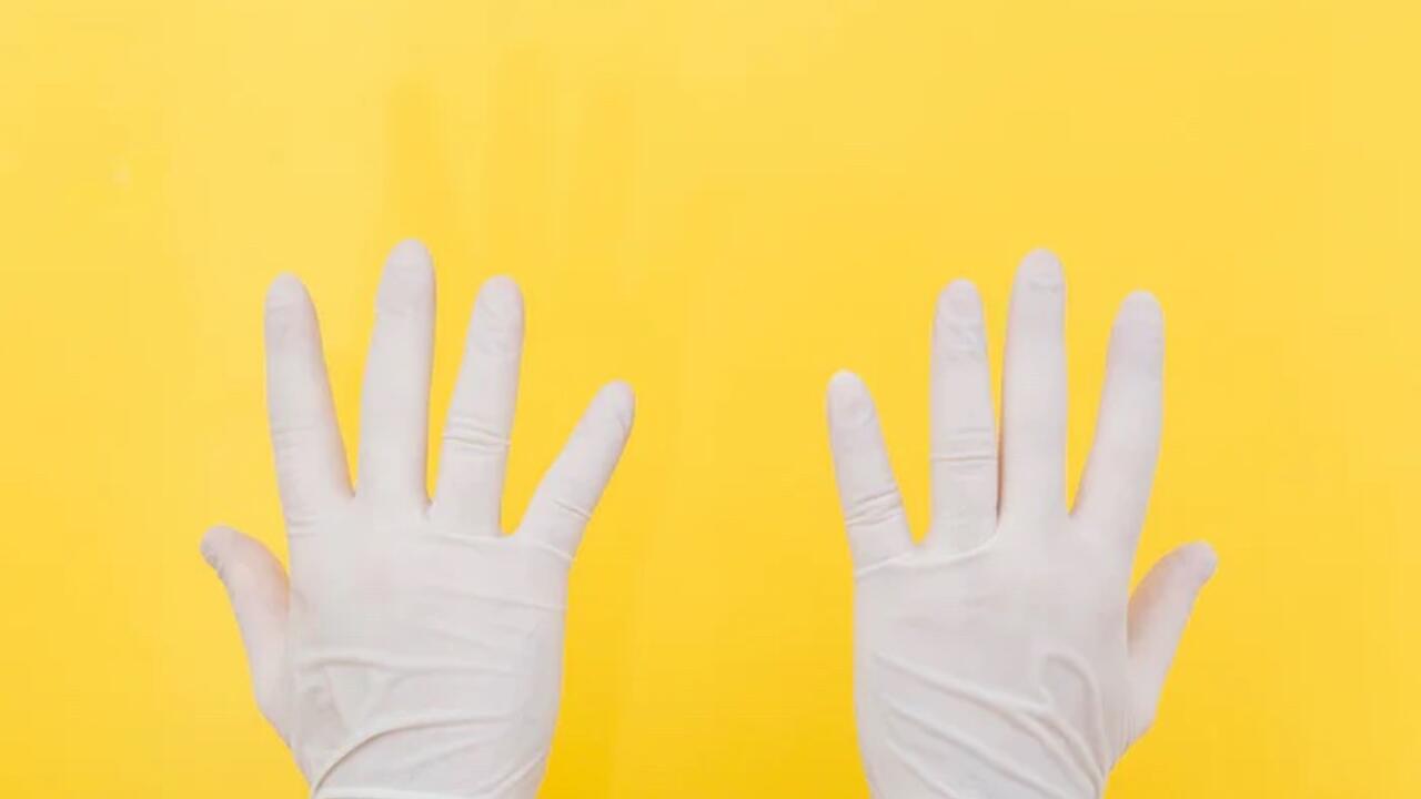 Dry Cleaners Employee Hands In Rubber Protective Gloves Removing