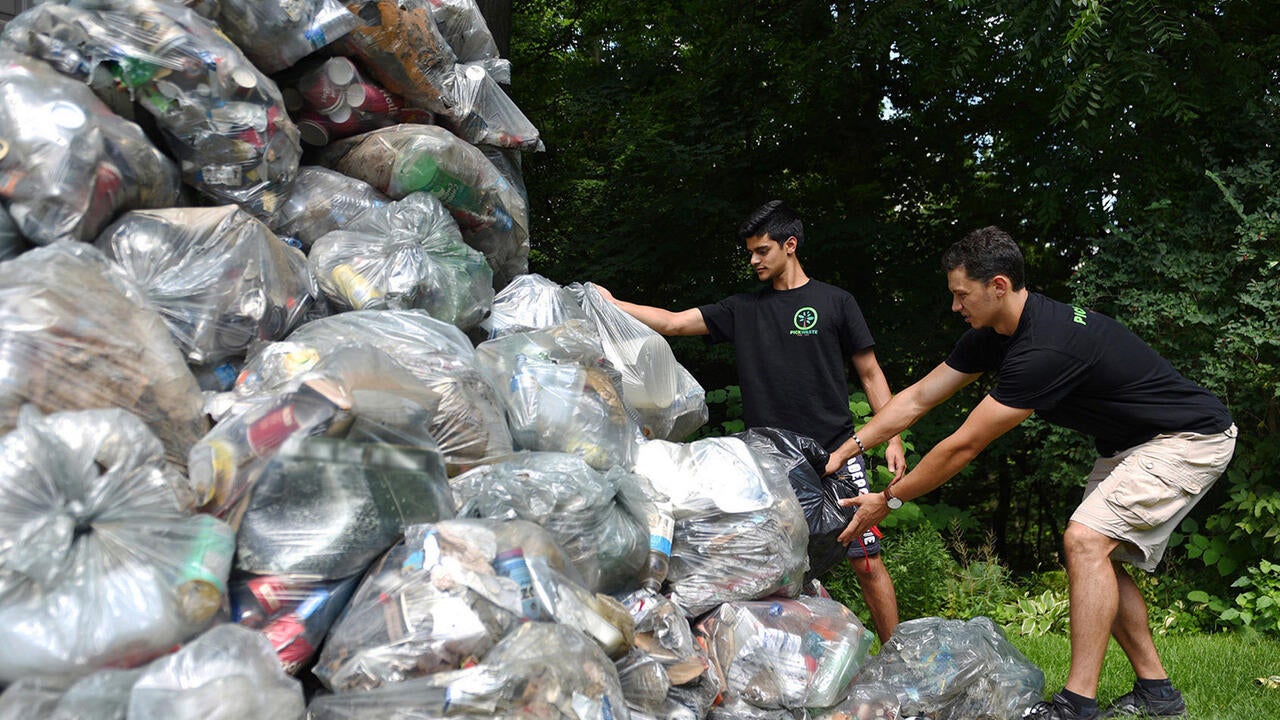 Pickwaste founders next to garbage bags