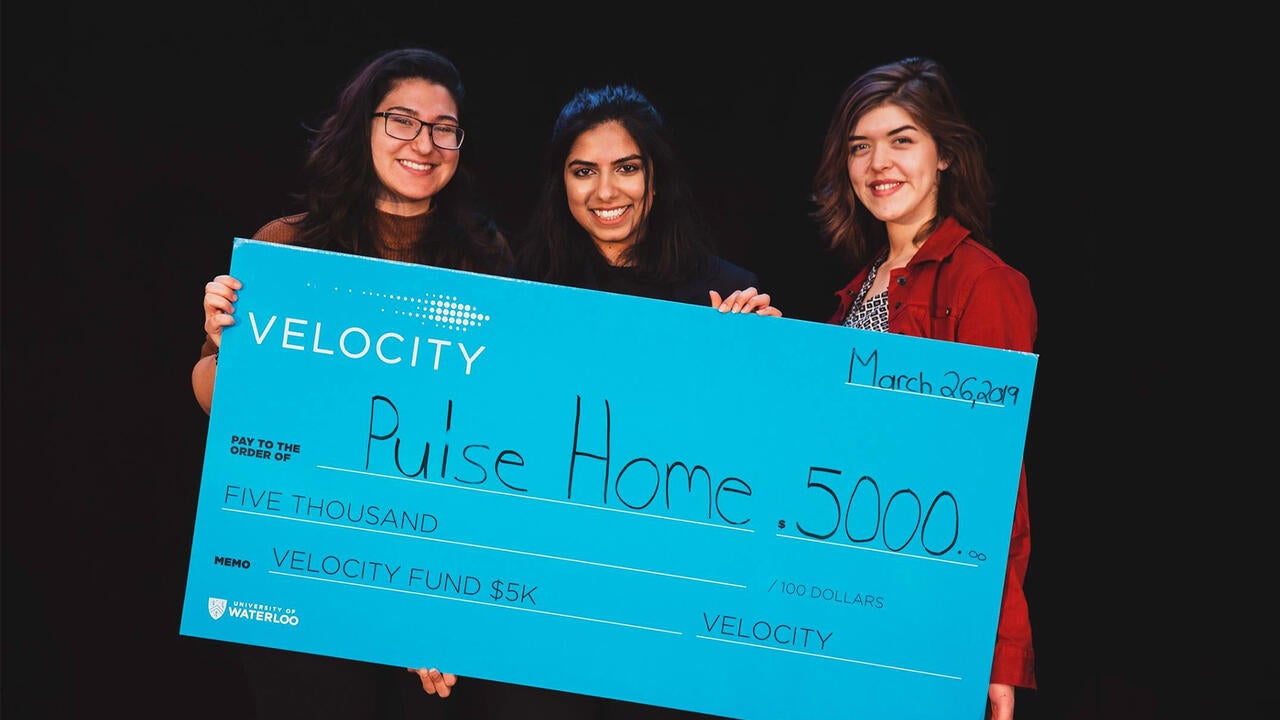 Emman Haider, Paula Przybylski and Sara Turner holding their cheque 