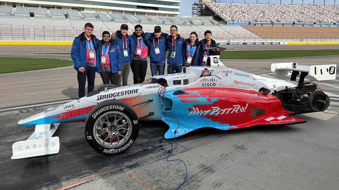 University of Waterloo students pose with their self-driving race car in Las Vegas.