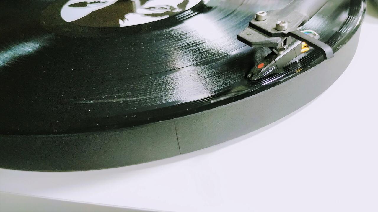An old-school vinyl album plays on a turntable.