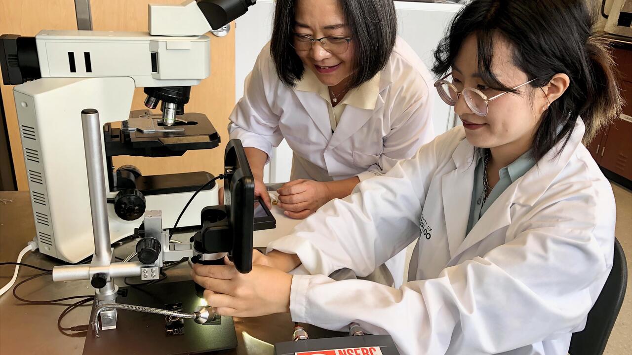 Dr. Carolyn Ren (left) works with new technology to detect E. coli bacteria in water with PhD student Qianying (Alice) Mao in he