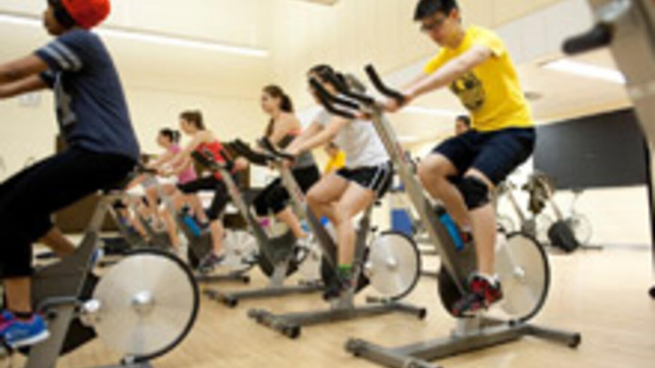 David Huang participating in a spin class on campus