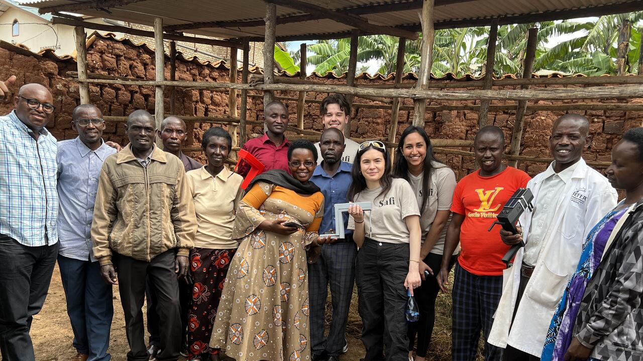 Three students, the founders of Safi, pose with several Rwandan farmers and administrators