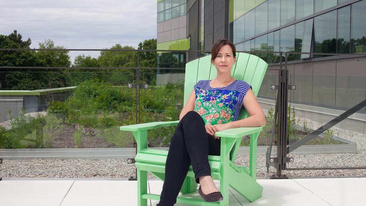 Director Sarar Burch sitting on a green muskoka chair