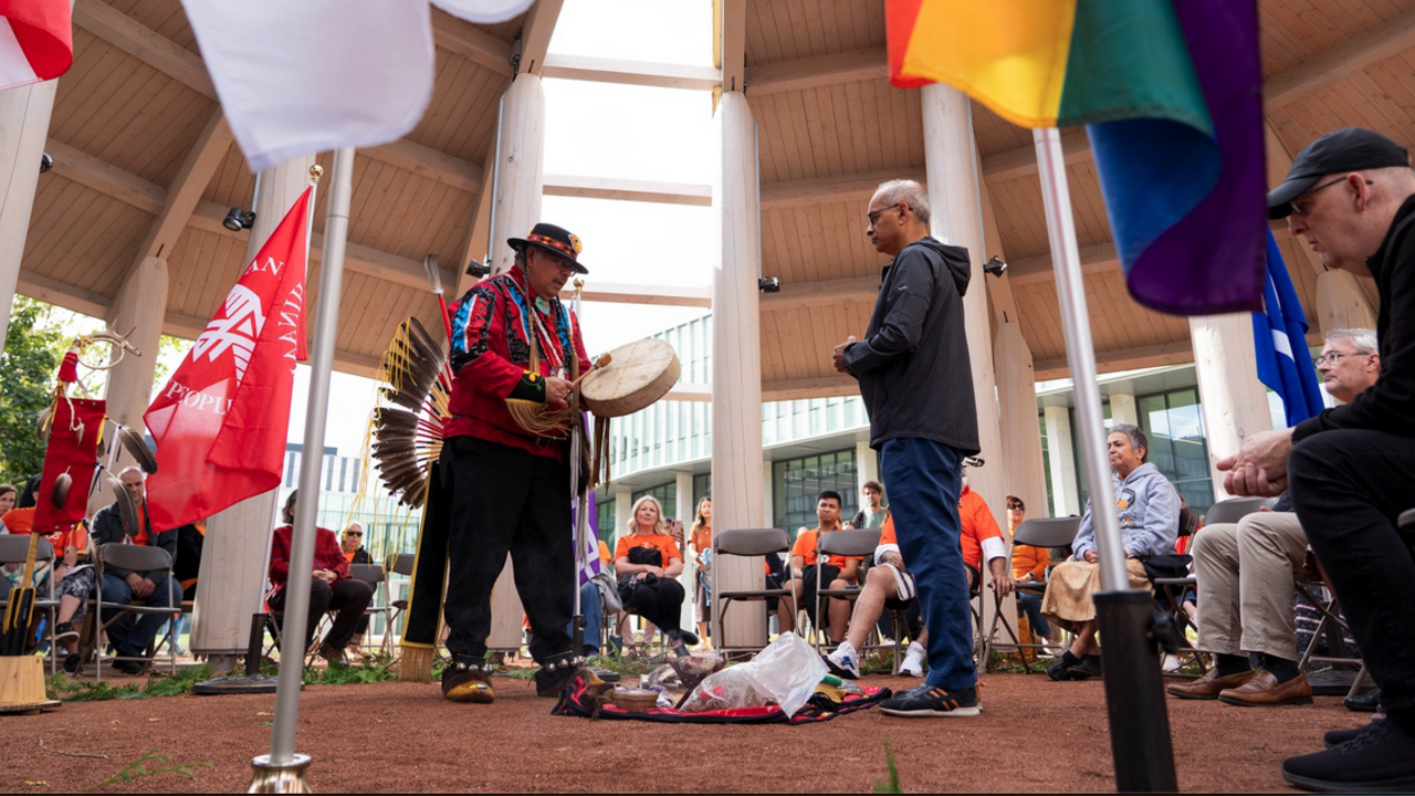 President Goel and Elder Myeengun standing in a circle of people exchanging words