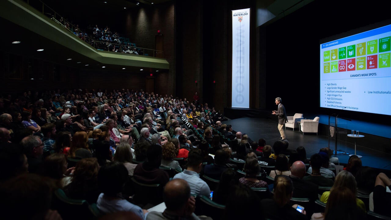 A large crowd of people gather in an auditorium