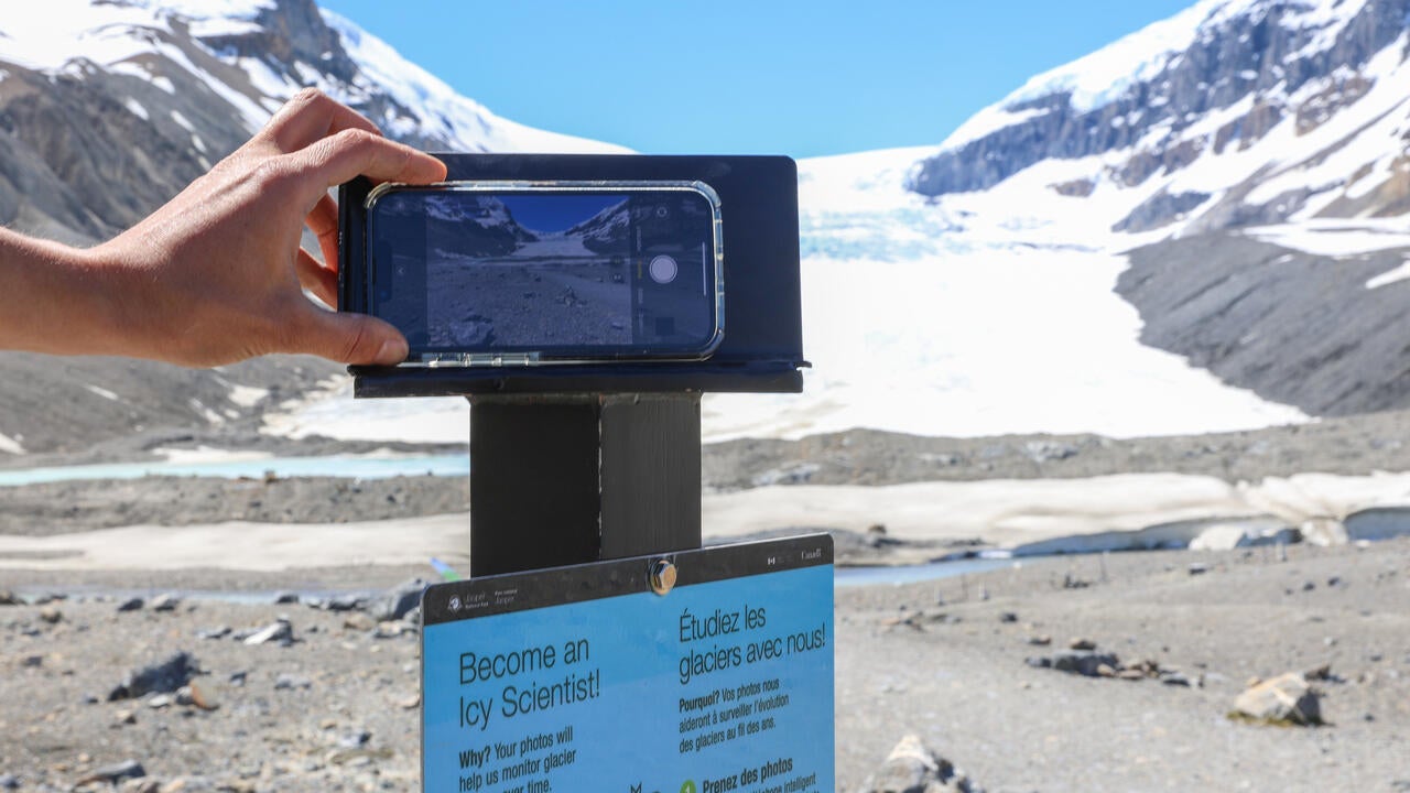 An iphone taking a photo of a glacier to help monitor the glacier over time.