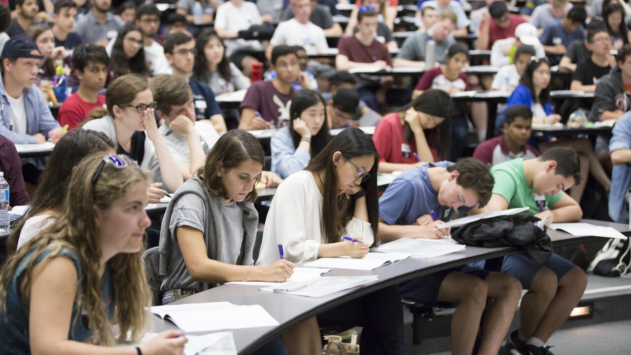 Students taking notes in a lecture hall
