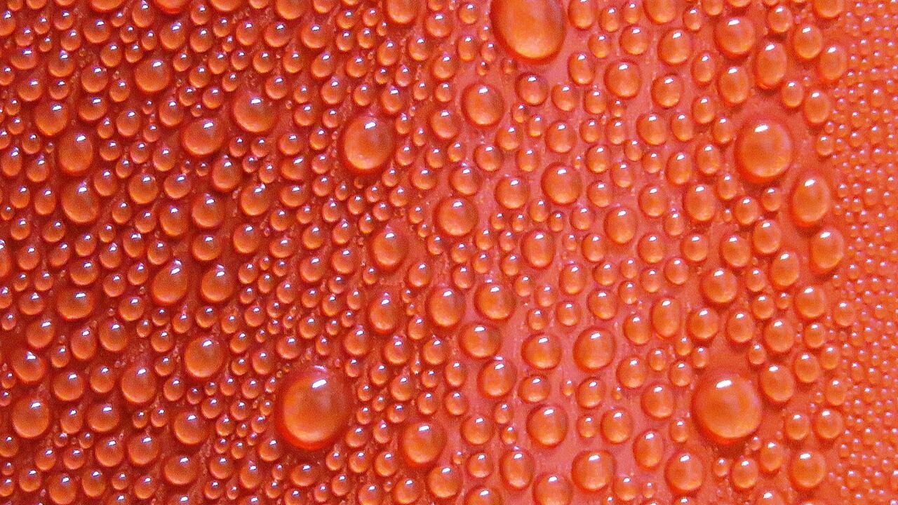 Red surface with sweat-like water beads on it