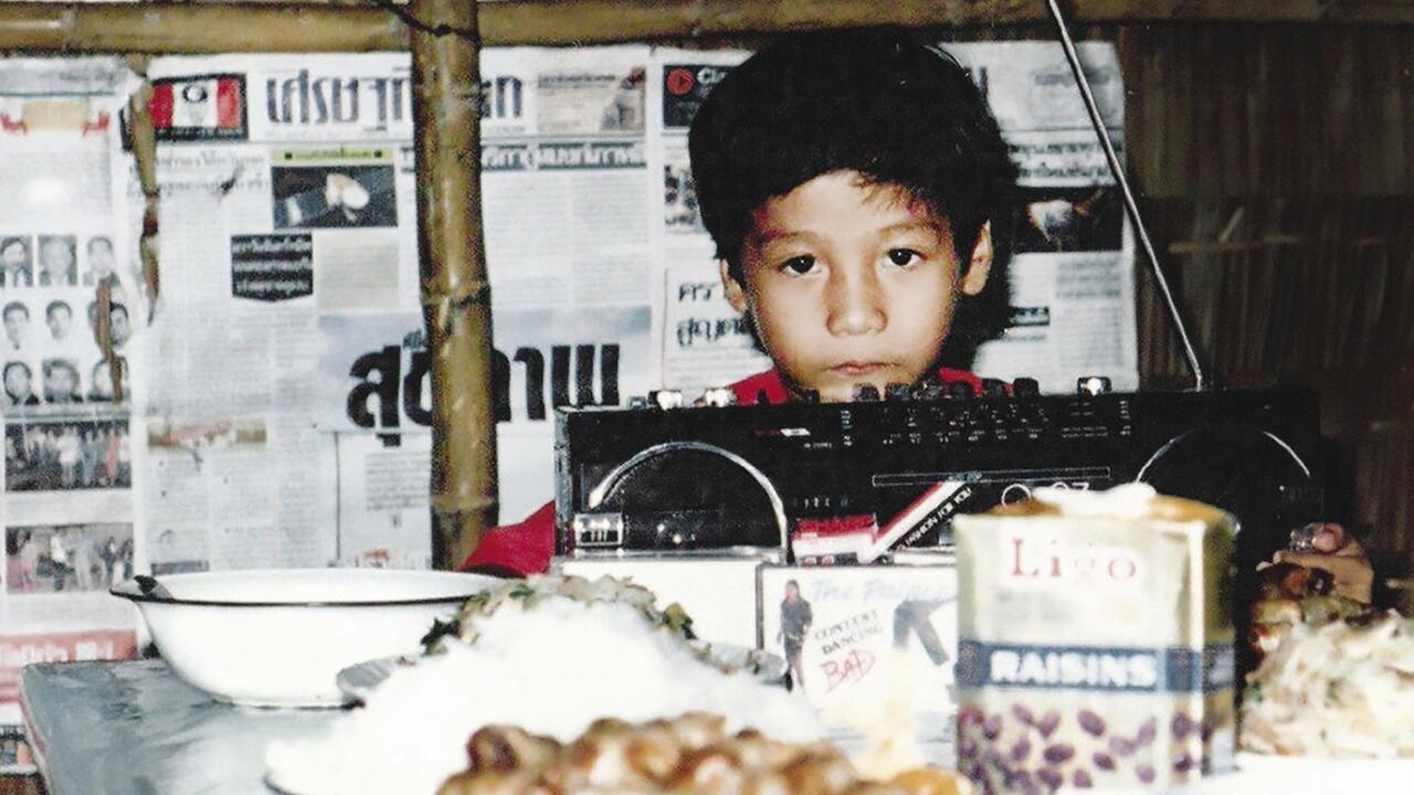 Archival photo of a young Vin Nguyen at his birthday part in a tent in a refugee camp