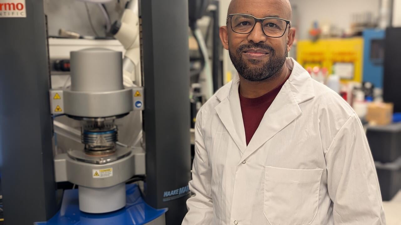 Waterloo researcher Dr. Tizazu Mekonnen stands next to a rheometer, which is used to test the flow properties of hydrogels.