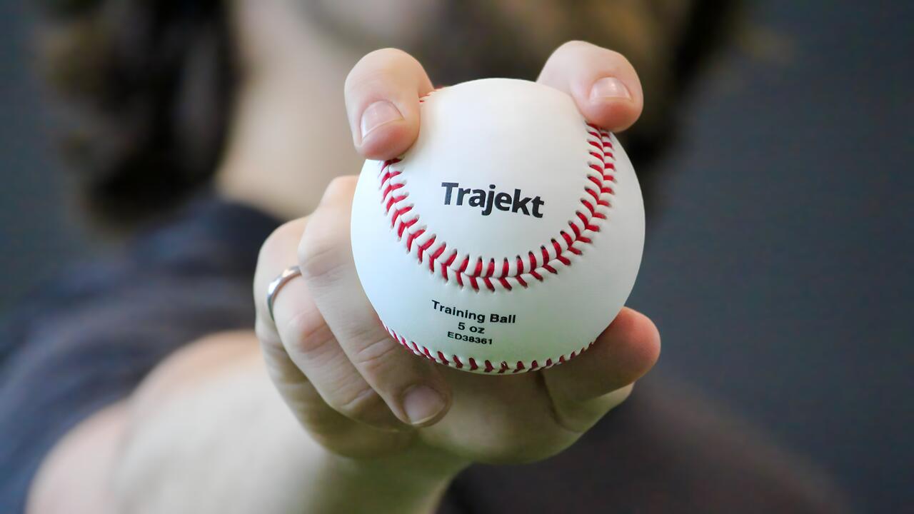 Person holds out a baseball with a fastball grip
