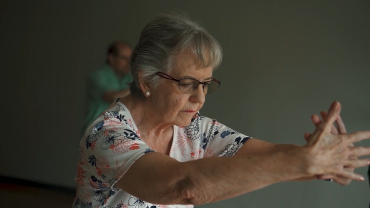 An elderly woman does stretching exercises