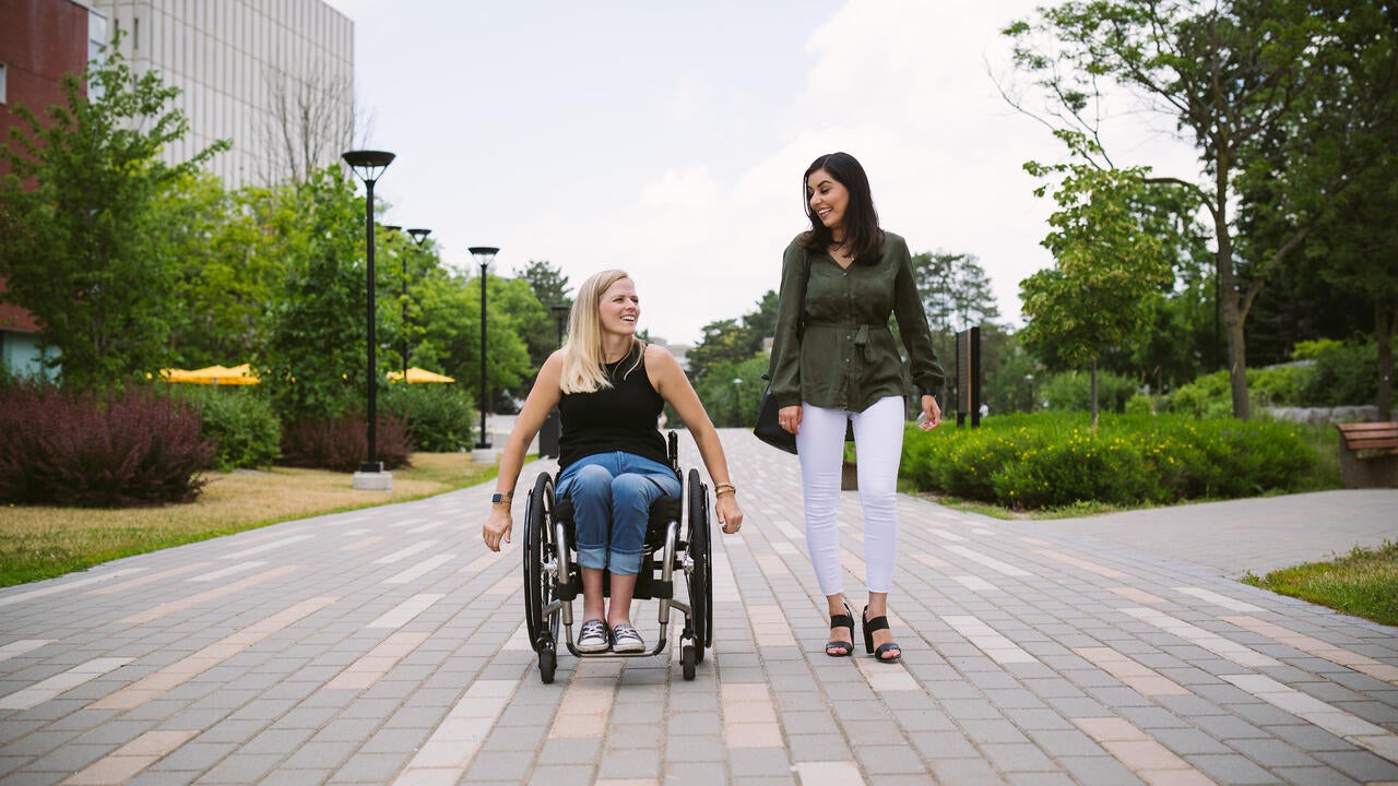 Woman wheelchair user and able-bodied friend on Waterloo campus