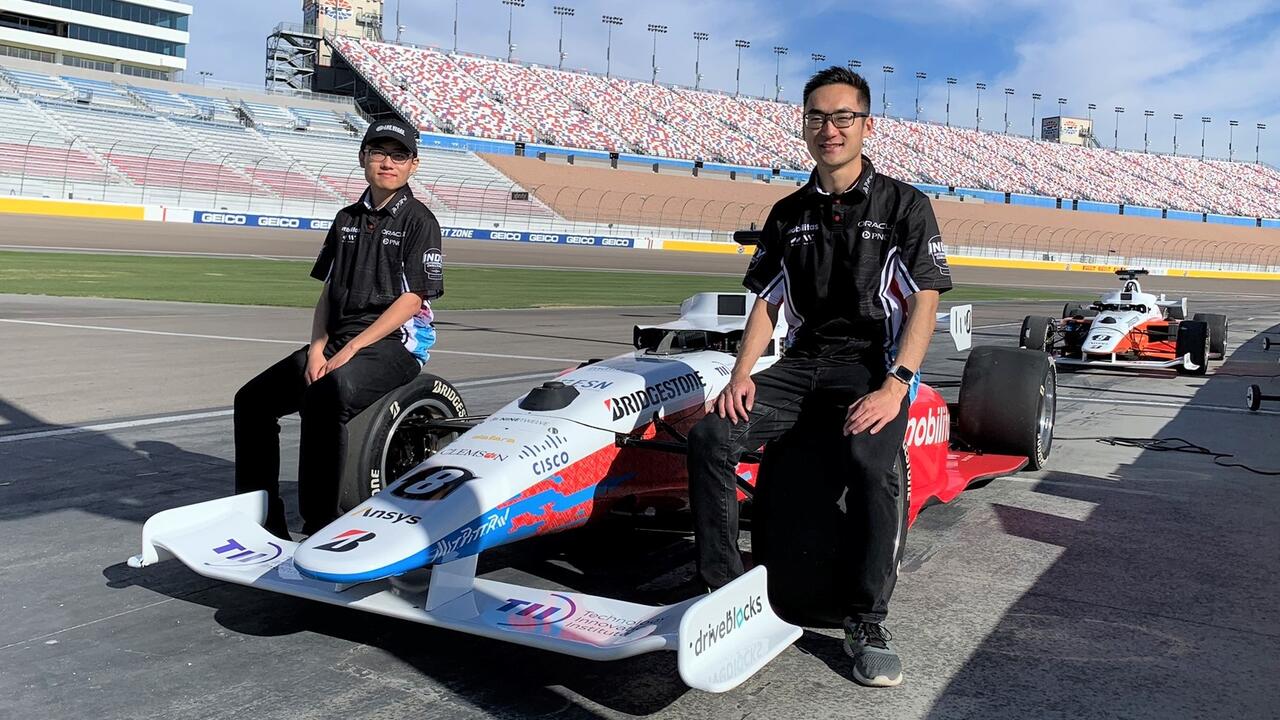Behn Zhang (left) and Brian Mao with their autonomous racecar at the Las Vegas Motor Speedway.