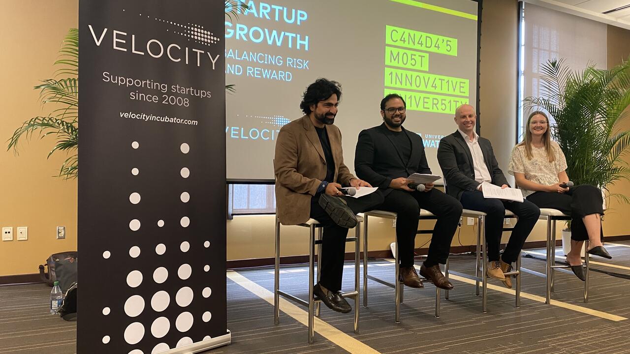 A panel of speakers from Velocity sitting in front of a screen