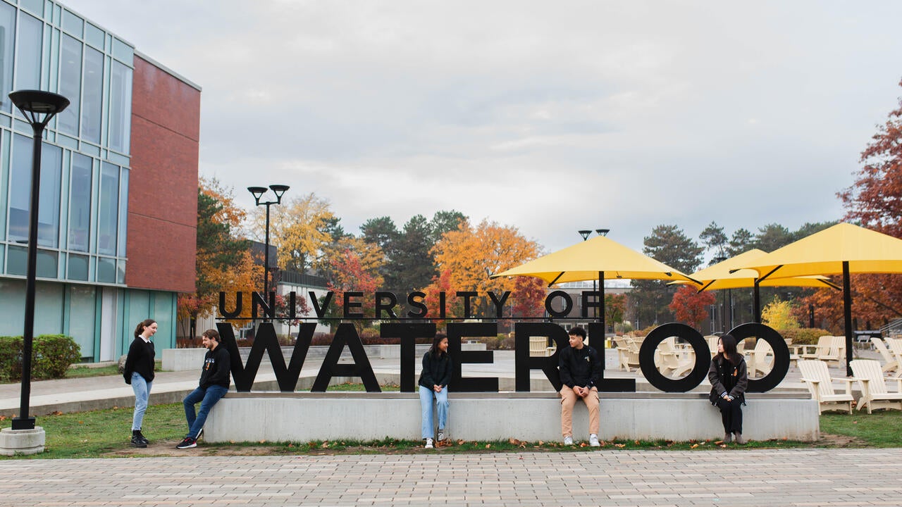 University of Waterloo students hanging out by the Waterloo sign