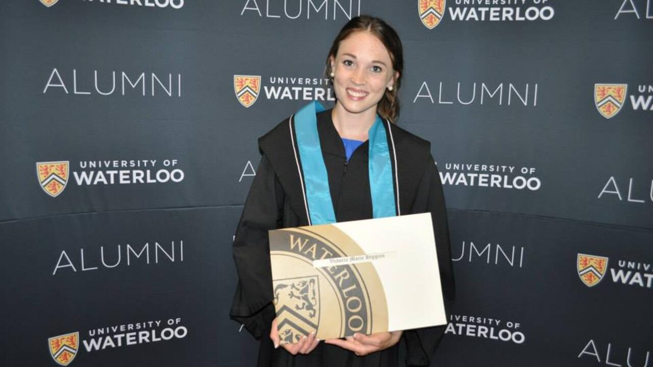 Victoria holding her diploma at convocation