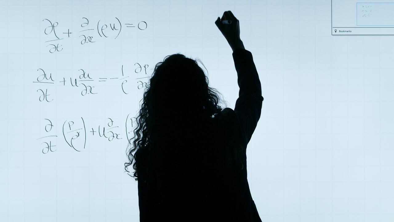 Silhouette of a woman, writing equations on a white background 