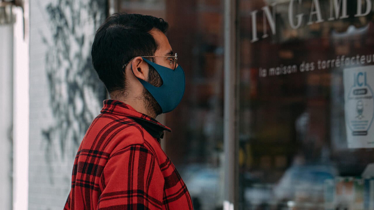 Man in a mask looking into window