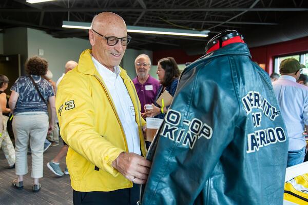 Alum inspects an old Waterloo jacket while wearing his own