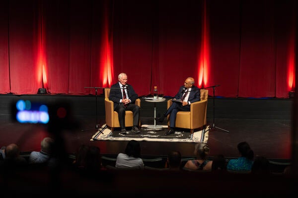 David Johnston and Vivek Goel seated on stage in discussion.