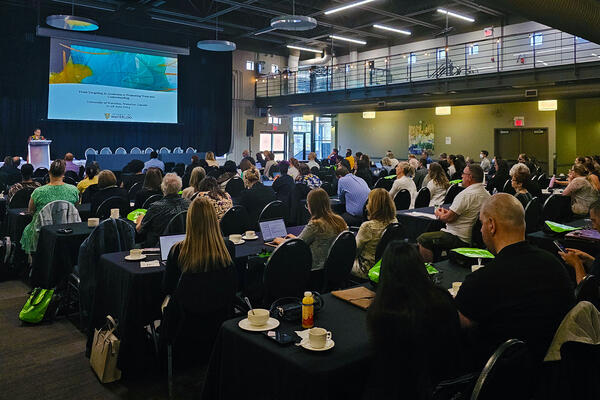 Room full of conference attendees seated at tables at Federation Hall