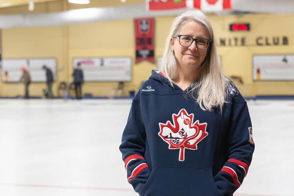 Heather Mair stands beside curling sheets at Waterloo's Granite Curling Club