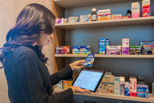 Dr. Nardine Nakhla holding a tablet and cross referencing medication with MAPflow database