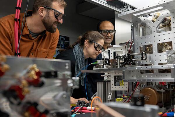 Cystal Senko examines OQD unit with Roger Melko and Rajibul Islam 