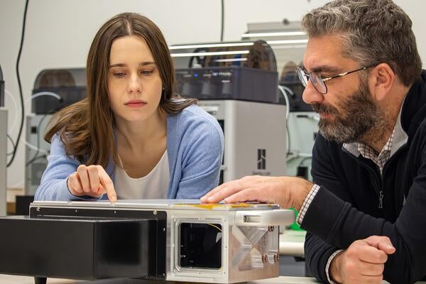 Alex Maieran examines test device in lab