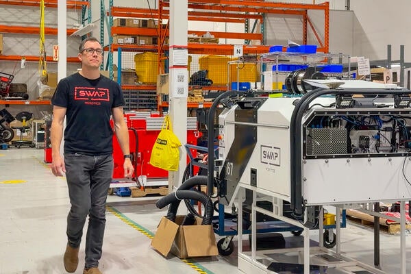 Tim Lichti walking through manufacturing warehouse where Swap Robotics is built