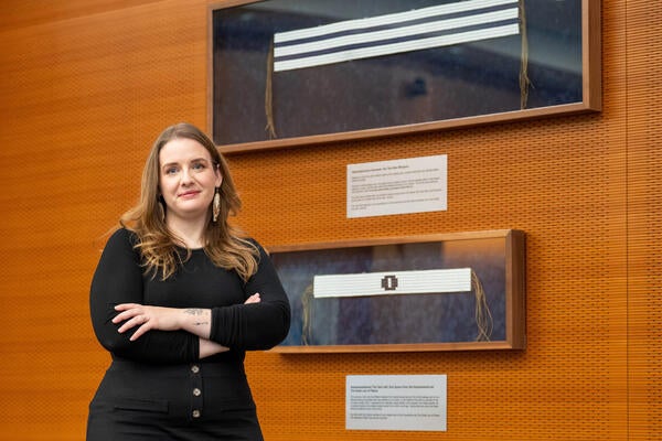 Savannah Sloat in front of framed Wampum belts