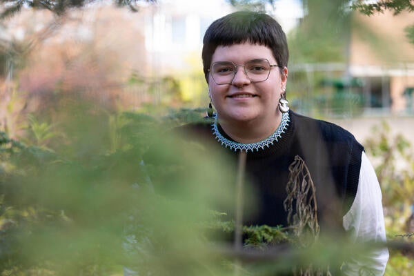 Tara Ryan looks through foliage in the woods