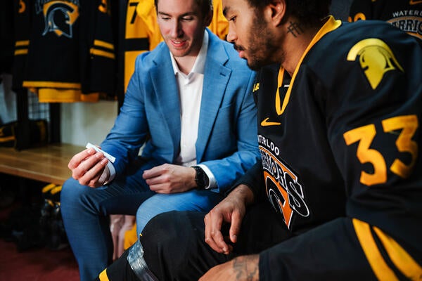 Andrew Cordssen-David showing a HeadFirst assessment test to a Waterloo Varsity Men's Hockey player