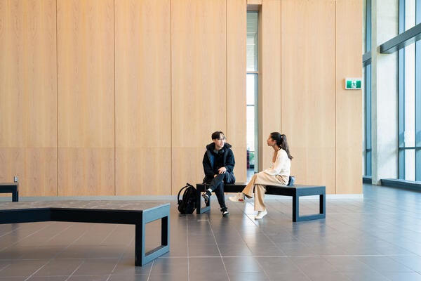 two students talking on a bench